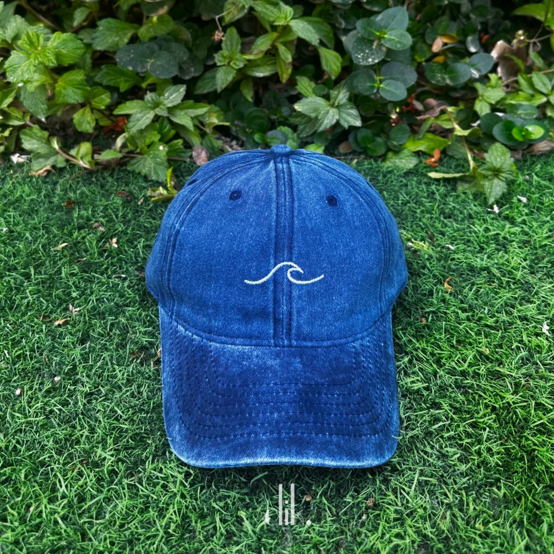 Blue cap with a white wave design on grass