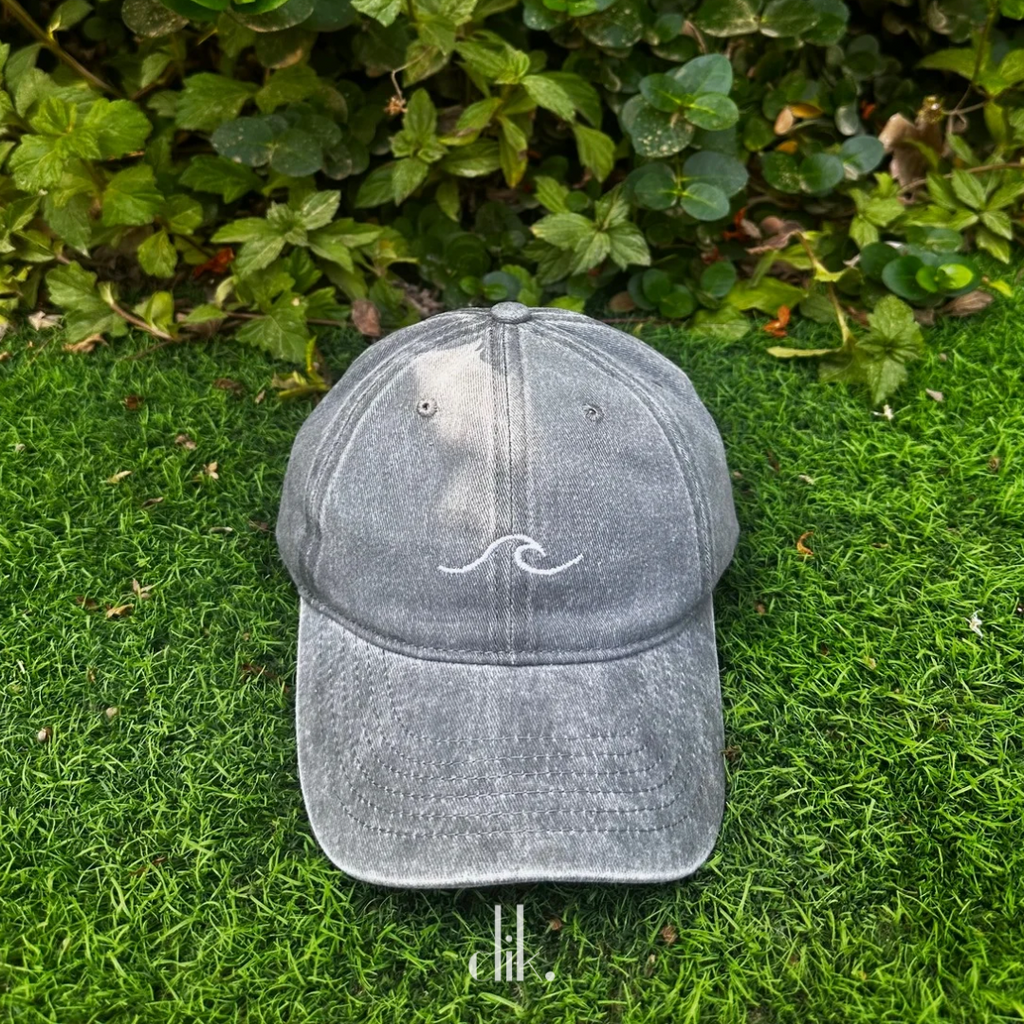 Gray cap with a white logo on grass